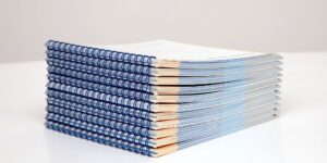 A stack of blue and white books on a white surface.