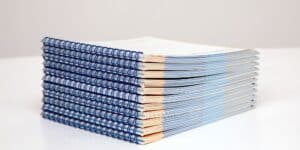 A stack of blue and white books on a white surface, showcasing high-quality printing Boise.