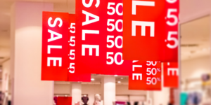 Red sale signs and other marketing materials prominently displayed in a store, designed to attract customers and increase marketing ROI.