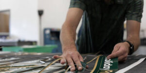 A print shop worker creates large format stickers for a business.