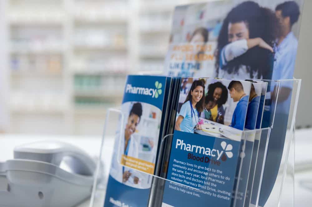 A set of colorful trifold brochures sit in a pharmacy showcasing the final stages of effective brochure creation